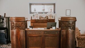 A wooden desk with a laptop, a mirror above it, and a patterned floor. - Green Sheep Boutique Hotel (Stepantsminda)