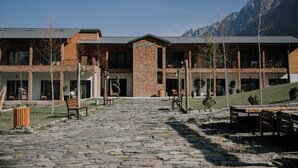 A building with a brick facade, multiple windows, and a sign that reads "Green Shoof." - Green Sheep Boutique Hotel (Stepantsminda)