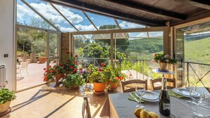 A sunlit patio with a table set for two, potted plants, and a bottle of champagne. - Villa Falcone (Piazza Armerina)