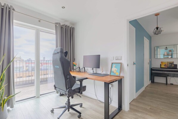 Un espace de bureau moderne comprenant un bureau, un ordinateur et une chaise de bureau.