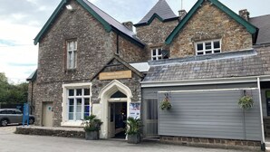 Un bâtiment en pierre sur lequel est apposée une enseigne indiquant : « Complexe de loisirs du manoir ».