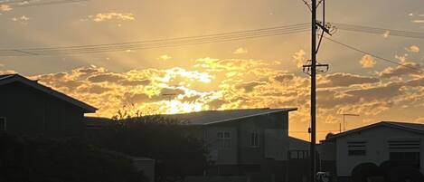 Atardecer sobre un barrio residencial con casas y un poste de luz.