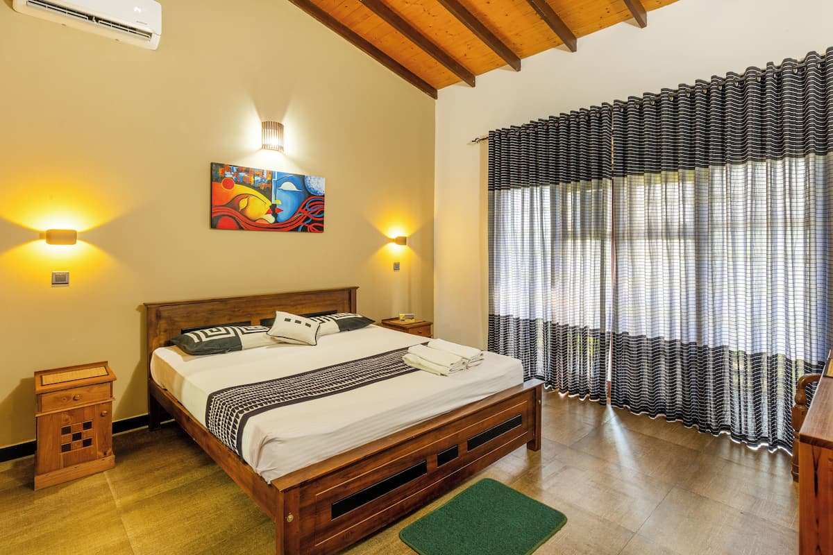Ein Schlafzimmer mit einem hölzernen Bett, zwei Nachttischlampen, einem Bild an der Wand und einem Fenster mit Vorhängen.