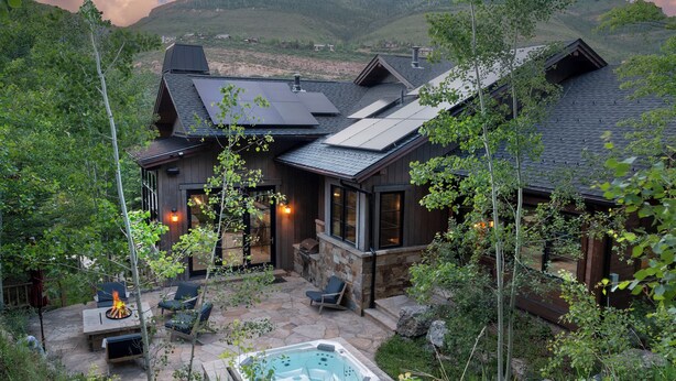 A house with a stone patio, outdoor seating, and a hot tub. - Vail Chalet | Platinum-Rated 4BR Luxury Home, Cascade (Vail)