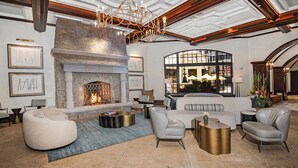 A spacious living room with a fireplace, comfortable seating, and a view of the outdoor patio.