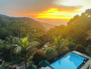 Una piscina al aire libre, sombrillas, tumbonas