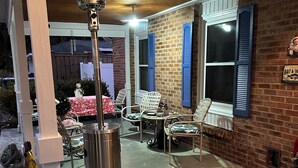 An outdoor patio area with a metal trash can, a bird statue, and a table with chairs. - Summertime!! Save money, one mile from the beach! Ok to smoke outside. (Myrtle Beach)
