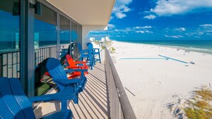 A balcony with blue chairs overlooking a beach. - Island Winds East 501 3 Bedroom Condo (Gulf Shores)