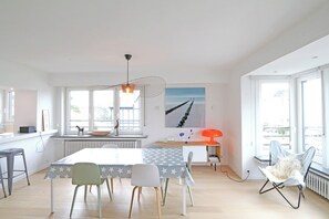 A modern kitchen with a dining table, chairs, and a view of the outside.