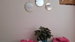 A bathroom vanity with a potted plant, two folded towels, and a 'Calm' sign. - The Hide - A Secret Cabin in the Trees: Peace Nature & Privacy! (Tiverton)