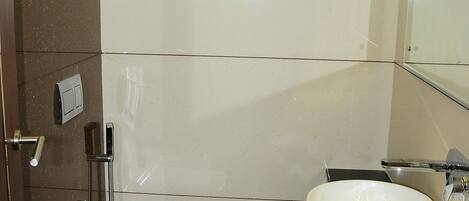 A modern bathroom with a toilet, sink, and mirror.