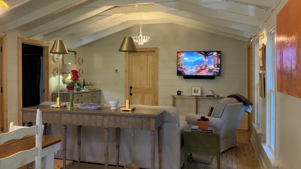 A cozy, open-plan living space with a kitchen area, a dining table, and a comfortable seating area.