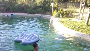 A swimming pool with a person using an inflatable float. - House in El Bosque Encantado (San Martín de Valdeiglesias)
