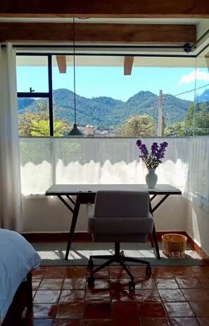 Un balcon avec une table, une chaise et un vase de fleurs.