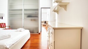 Une chambre d’hôtel avec un lit, une armoire et une commode.