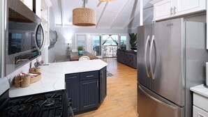 A modern kitchen with a central island, stainless steel appliances, and a view to the outside. - Ocean front Scituate Minot Beach Front Sleeps 11 (Scituate)