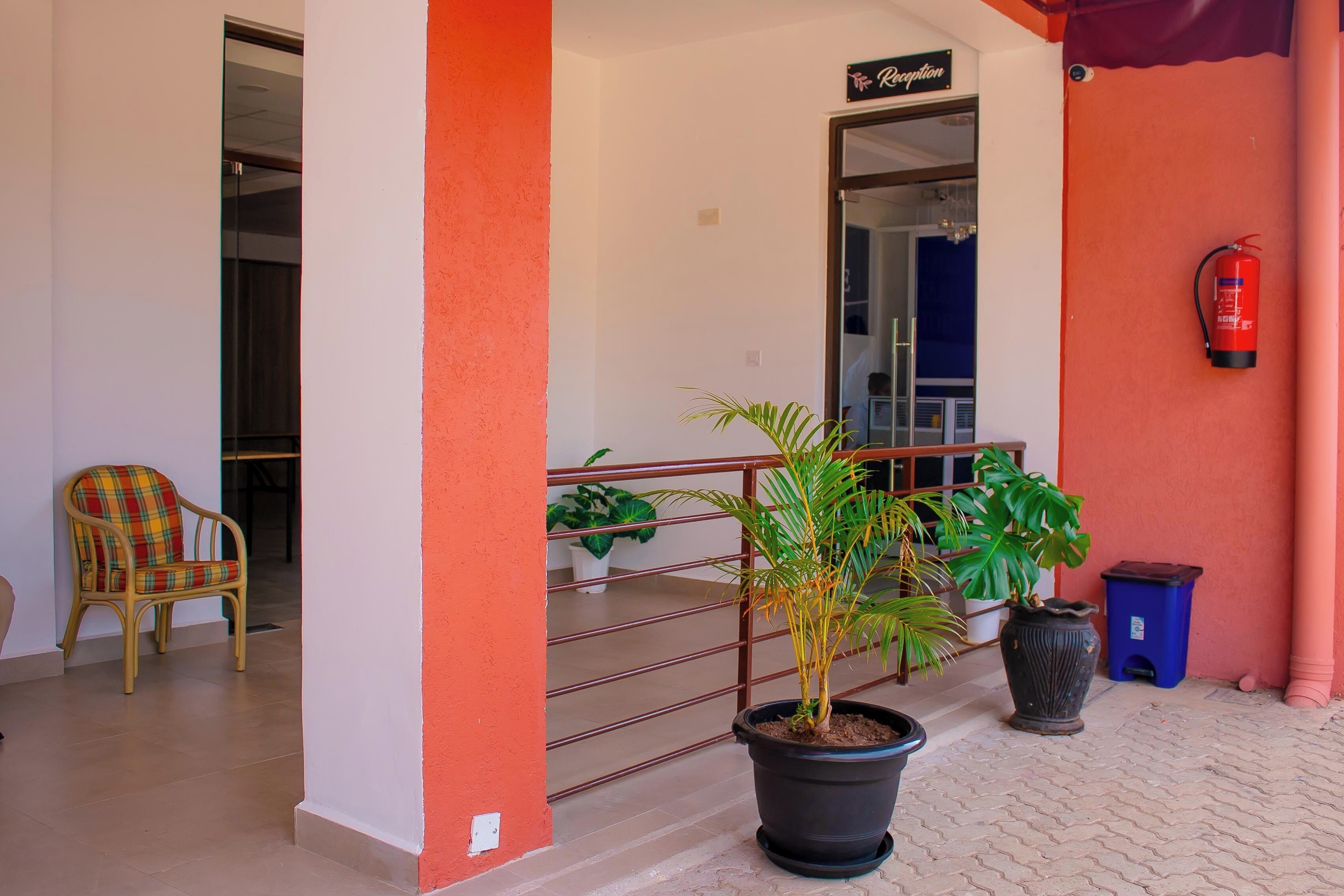 A reception area with a chair, potted plants, and a fire extinguisher.