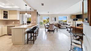 A spacious kitchen with a large island, a dining area with a fireplace, and a living room with a sofa and a TV. - Mins To Beach, Perfect For Families, Amazing Views (Newport Beach)