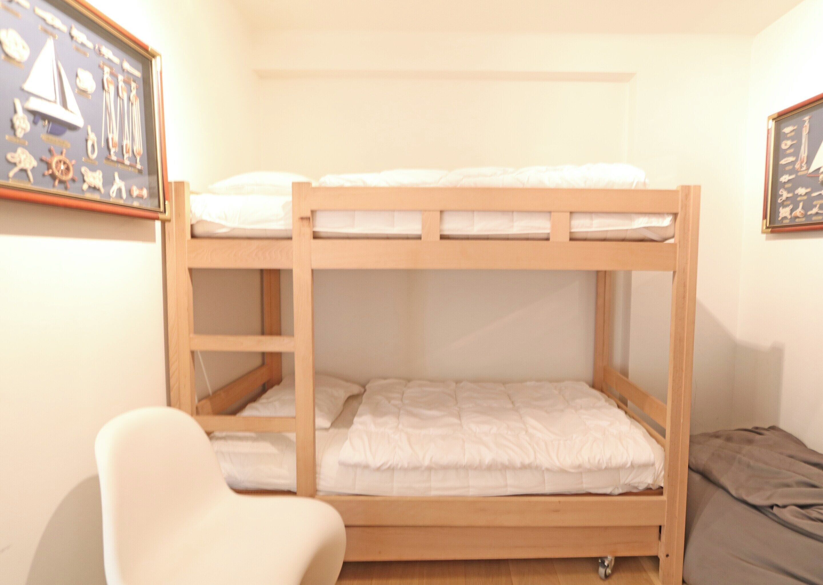 A bunk bed room with a framed nautical chart on the wall.