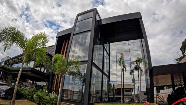A modern building with large glass windows and a stone base. - Terraço Plaza Hotel (Jaboticabal)