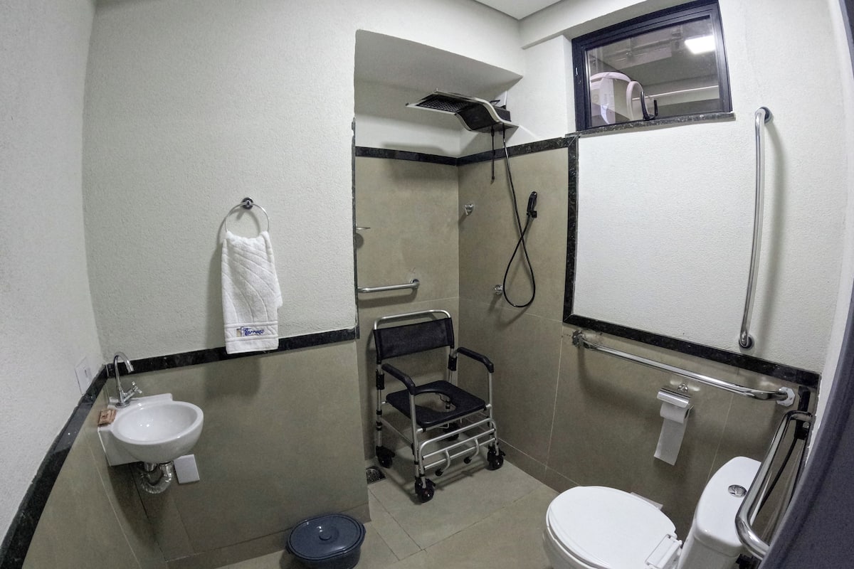 Une petite salle de bain compacte, équipée d’un lavabo, de toilettes et d’une douche.