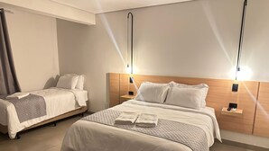 A hotel room with two beds, a wooden headboard, bedside tables, and wall-mounted lights. - Terraço Plaza Hotel (Jaboticabal)