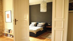 Une chambre à coucher avec un lit, une table de chevet, une lampe et une bibliothèque.