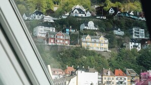 A view from a window overlooking a hillside with houses.
