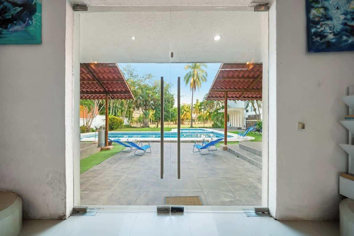 Vue d’un espace piscine avec deux chaises longues et un coin salon abrité.