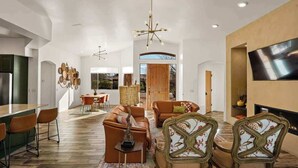 A spacious living area with a modern kitchen, a dining area, and a seating area with a fireplace. - Myrinn| Yard w/ Hot Tub, Fire Pit & Red Rock Views (Sedona)