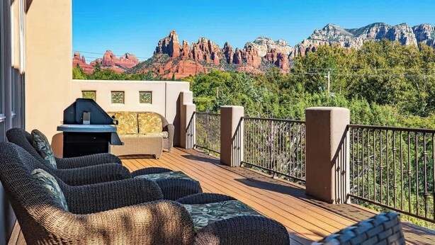 A deck with wicker furniture and a grill, overlooking red rock formations. - Myrinn-360° Red Rock Views, Balcony & Creek Access (Sedona)