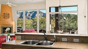 A modern kitchen with a large window overlooking a mountainous landscape. - Myrinn-360° Red Rock Views, Balcony & Creek Access (Sedona)
