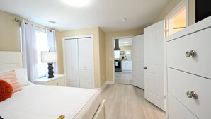 Une chambre à coucher avec un lit, une table de chevet et une vue sur la cuisine.