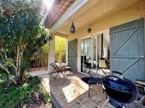 An outdoor patio with a grill, a table, and chairs. - Charming villa with swimming pool in a quiet area close to the sea (Toulon)