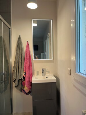 A bathroom with a white sink, a mirror, and a towel rack with two towels. - Charming villa with swimming pool in a quiet area close to the sea (Toulon)