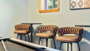 A pool table in a room with three upholstered chairs with a unique braided design. - Fun Midcentury Home | Hot Tub | Karaoke | Games (Lancaster)