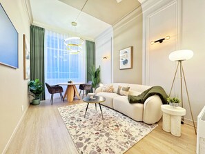 A modern living room with a round coffee table, a beige sofa, and a floor lamp.