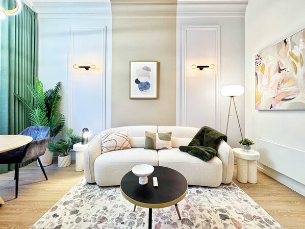 Una sala de estar moderna con un sofá, una mesa de centro y un cuadro en la pared.