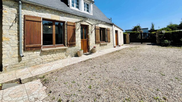 A stone building with a gravel driveway, wooden shutters, and a tiled entrance. - La Maison d Utah , Beach and Memory (Sainte-Marie-du-Mont)