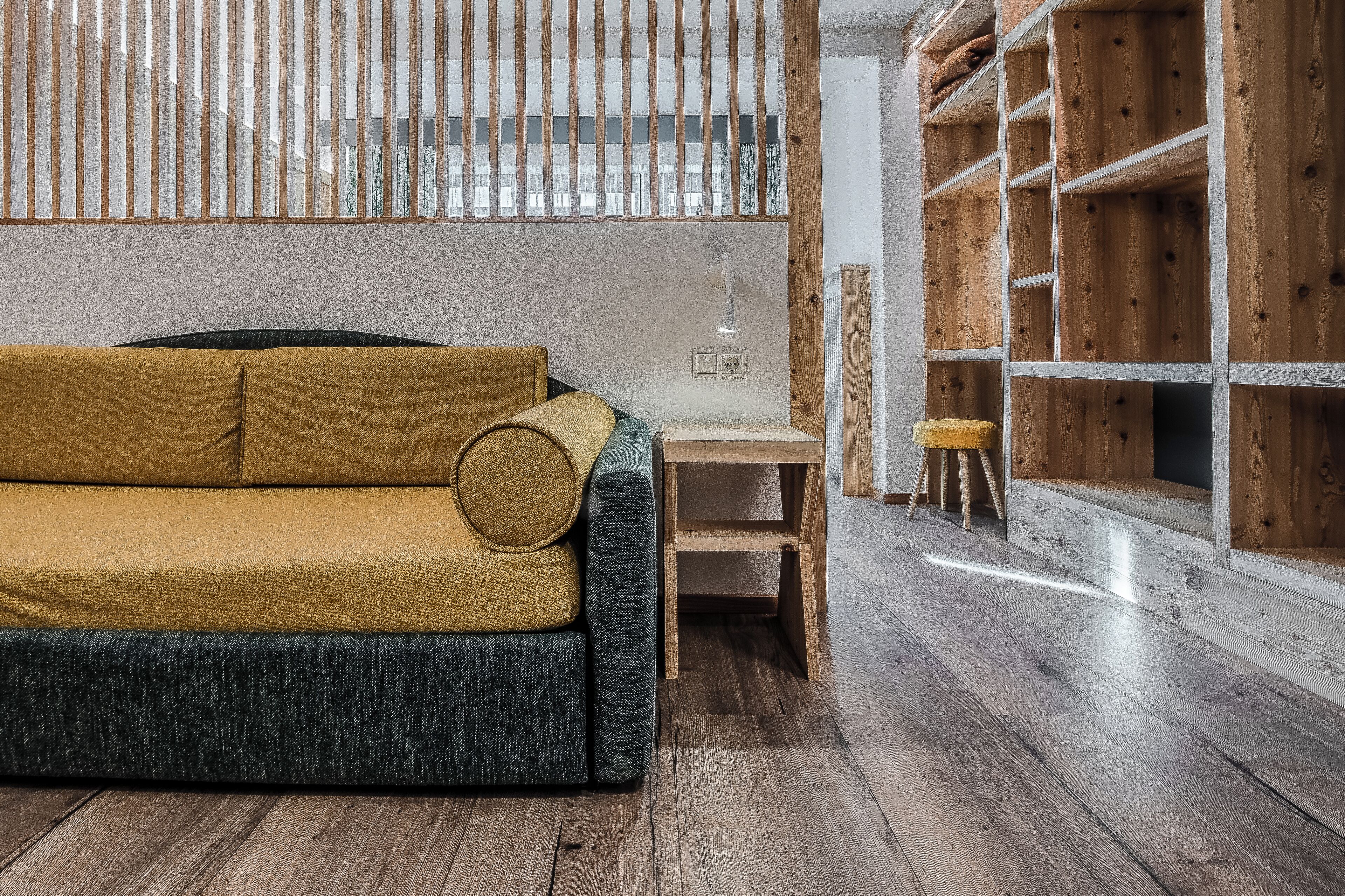 Un salon moderne avec un canapé, une table en bois et une bibliothèque intégrée.