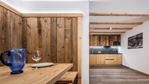 A modern kitchen with wooden cabinets and a black countertop. - Residence Ada (San Cassiano)