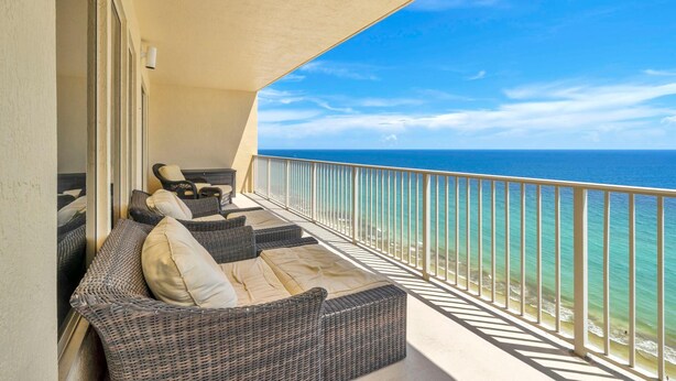 A balcony with wicker furniture and a view of the ocean. - Gulf Crest 2105b (Panama City Beach)