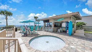 A pool area with a bar, outdoor seating, and a view of the ocean. - Gulf Crest 2105b (Panama City Beach)