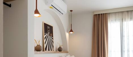 A hotel room with two beds, a built-in shelf, a wall-mounted air conditioner, and a pendant light.