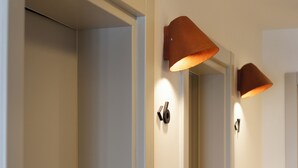Ein Flur mit Türen und Wandleuchten.