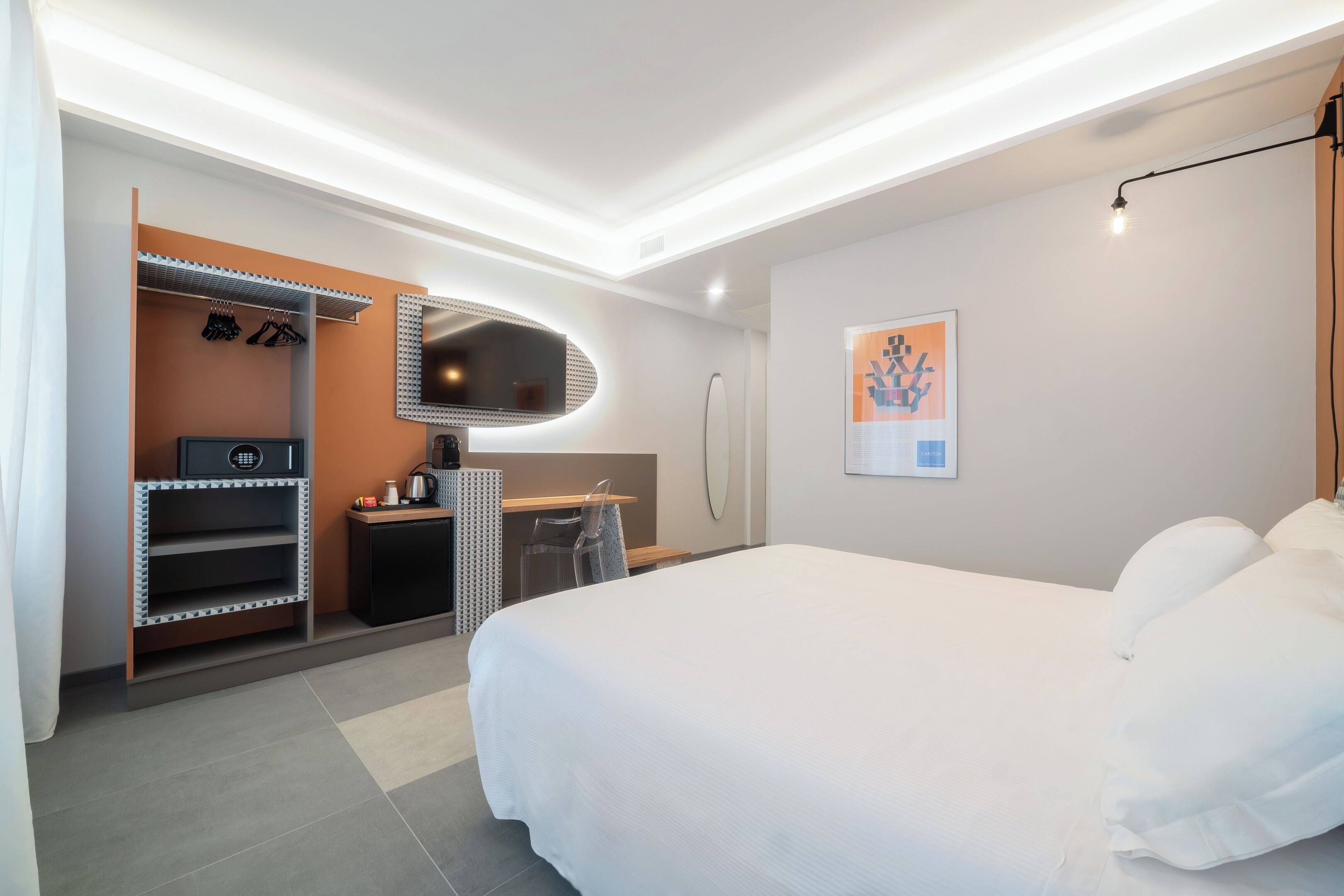 Una habitación de hotel moderna con una cama grande, un escritorio con silla, un armario y un baño.
