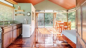Una cocina amplia con armarios de madera, un refrigerador y un comedor con mesa y sillas.