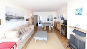 Ein großzügiger Wohnbereich mit einer Couch, einem Esstisch und einem Kamin.