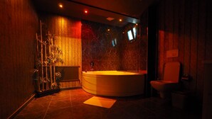 Une salle de bain moderne avec une grande baignoire, des toilettes et une plante en bambou.