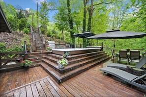 A wooden deck with outdoor furniture, a barbecue area, and a staircase leading to a deck. - Modern, Luxurious Cabin for Two located on a Cascading Waterfall. (Jasper)
